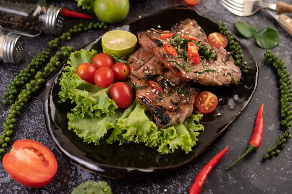 bife-de-porco-fatiado-coberto-com-gergelim-branco-e-sementes-de-pimenta-fresca-junto_1150-24780