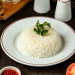 vista-lateral-de-um-prato-com-arroz-cozido-com-salsa-em-cima-da-mesa_140725-12126