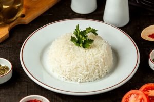 vista-lateral-de-um-prato-com-arroz-cozido-com-salsa-em-cima-da-mesa_140725-12126