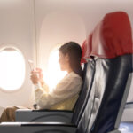 beautiful-asian-woman-is-working-with-smartphone-tablet-airplane