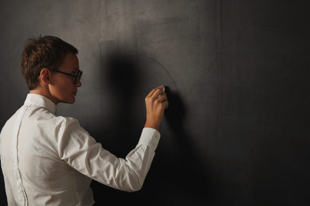 Teacher in white blouse at the blackboard