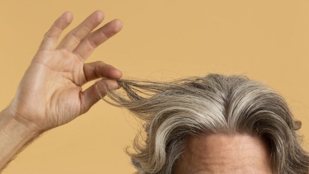 elder-man-holding-his-gray-hair