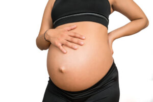 Pregnant woman touching her big belly.
