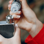 Stylish young girl  in a city with vape