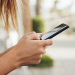 mulher-jovem-segurando-pretas-smartphone