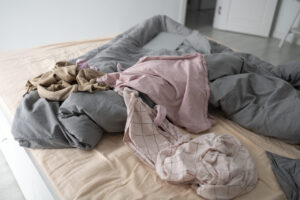 quarto-baguncado-com-roupas-na-cama-de-alto-angulo