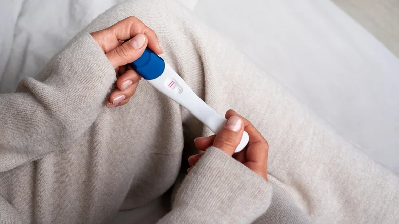 mulher-de-alto-angulo-segurando-testes-de-gravidez-positivos-1