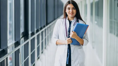 medico-feminino-atraente-em-pe-com-documentos-no-hospital-1