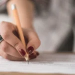 mão em destaque de mulher fazendo prova de concurso foto freepik