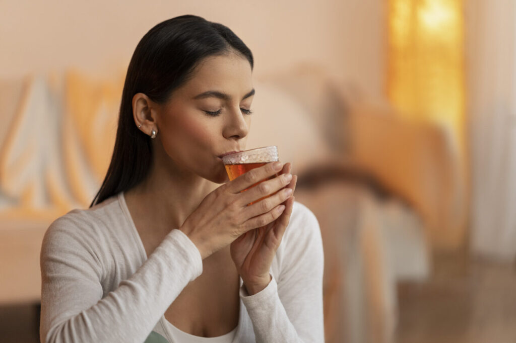 tiro-medio-mulher-segura-bebida
