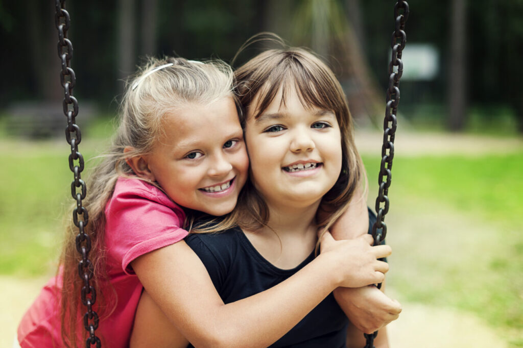 Best friends swinging in a park