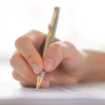 Hand with pen over application form