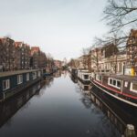 Wide shot of old apartment buildings and boathouses by the lake