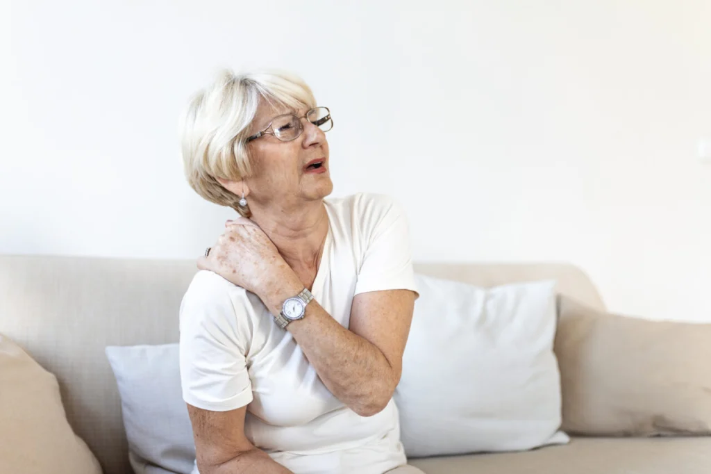 Close up of sad senior lady with neckache. Senior woman with chronic pain syndrome fibromyalgia suffering from acute neckaches. Senior woman suffering from neck pain