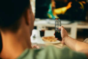 Close-up of man watching TV at home.