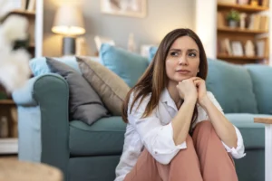 Pensando, triste e mulher em casa no chão com ansiedade por problema imagem istock